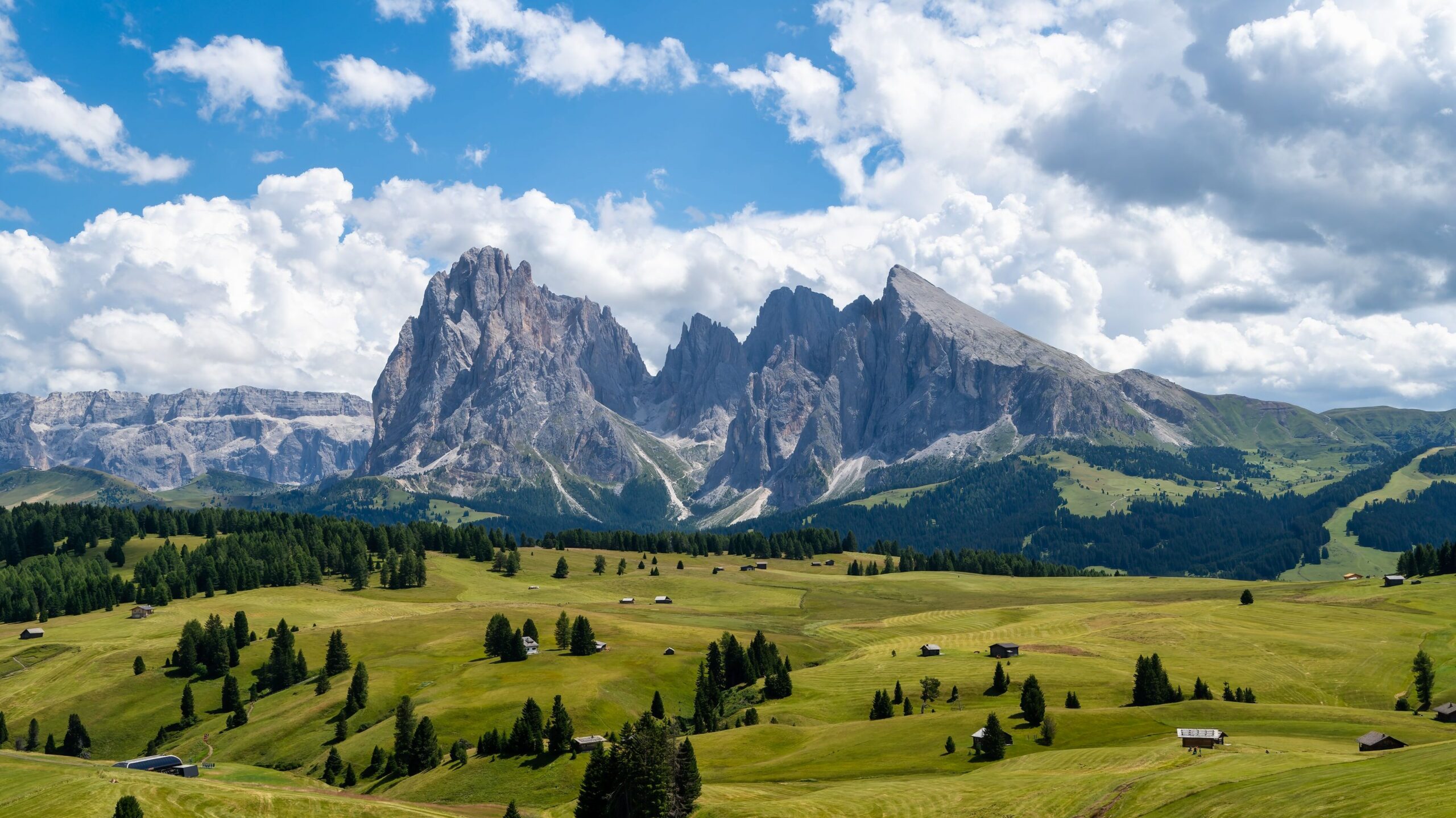 Stunning landscape of the Dolomites in Alpe di Siusi, showcasing vibrant green fields and dramatic peaks.